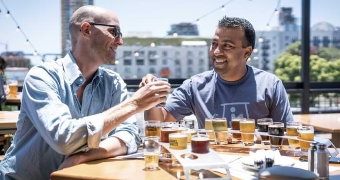 deux hommes en terrasse durant un date à boire des bières de dégustation